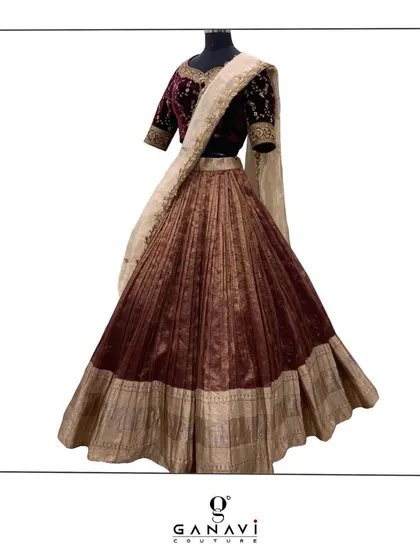 A classic lehenga set featuring a deep maroon velvet blouse with gold embroidery. This timeless combination is perfect for a traditional wedding ceremony or a festive celebration, exuding elegance and grace.