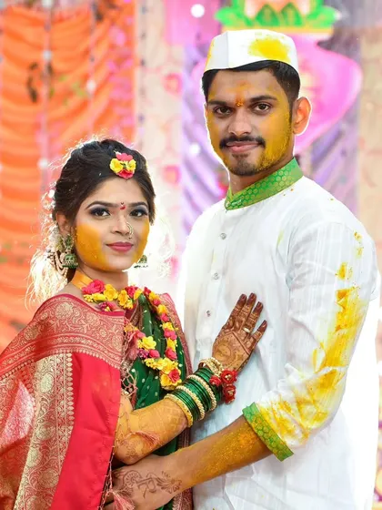 A portrait of the couple after their Haldi ceremony, showcasing the afterglow and traditional green and red attire.