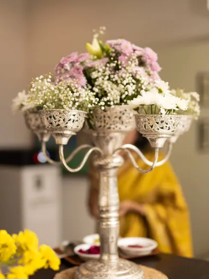 An elegant silver candelabra filled with delicate pink and white flowers serves as a beautiful and sophisticated centerpiece.