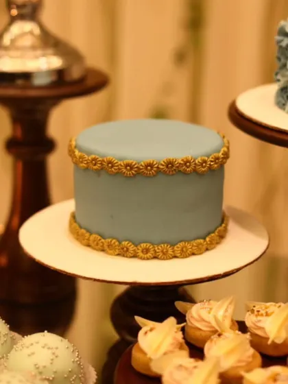 An elegant, minimalist cake with a smooth pastel blue finish and intricate golden border. This is an example of our artisan cakes, perfect for sophisticated celebrations.
