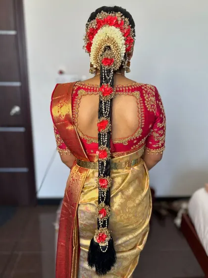 A detailed look at a traditional South Indian bridal braid for Prerana. This intricate hairstyle, adorned with beautiful flowers and jewels, is a specialty of mine and completes the classic Muhurtham look.