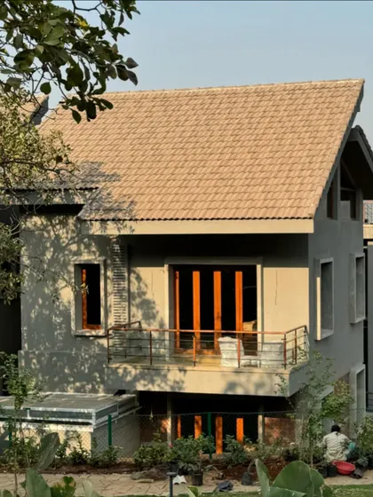The exterior of the 6AM House under construction. The design uses a simple pitched roof and a combination of concrete and wood, creating a modern yet grounded architectural form.