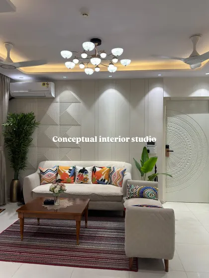A comfortable and timeless living room design at Nirala Estate. The space is bright and airy, with colorful cushions adding a playful touch to the neutral sofa.
