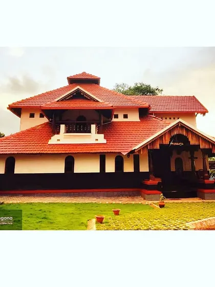 The main facade of the completed Udupi residence. The combination of white lime-plastered walls, a dark base, and the expansive red-tiled roof creates a striking and classic traditional look.