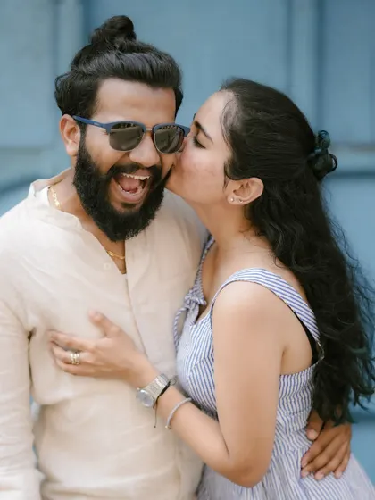 A sweet kiss on the cheek is a timeless expression of affection. This candid moment from a pre-wedding shoot is full of warmth and genuine emotion.