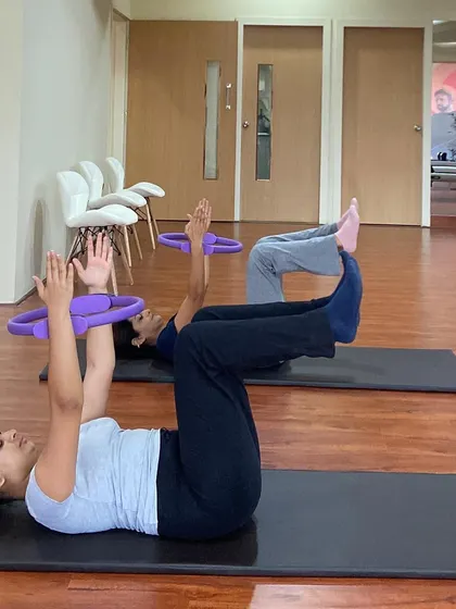 The concentration and precise form shown here are what we strive for in every session. The Pilates ring helps maintain inner thigh engagement and core stability.