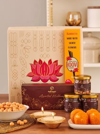 A beautiful corporate Diwali box featuring a lotus design, containing laddoos, assorted mukhwas, and sacred flower agarbatti.
