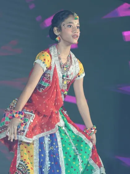 A close-up of a performer in her beautiful, multi-colored traditional costume for the folk dance act.