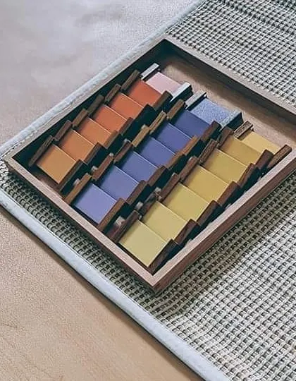 The color tablets are a key sensorial material used to refine a child's chromatic sense. This set, known as Color Box 3, challenges the child to grade nine different shades of color, developing a keen eye for detail and an appreciation for beauty.