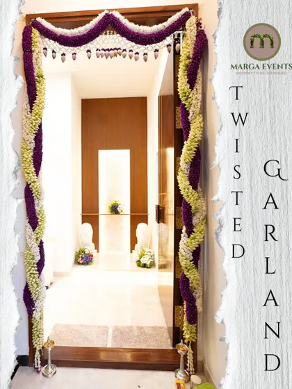 Details matter. This twisted garland, or 'thorana', was handcrafted with fresh jasmine and purple flowers to adorn the main doorway. It's a beautiful and traditional way to welcome guests and positive energy into the home for any celebration.