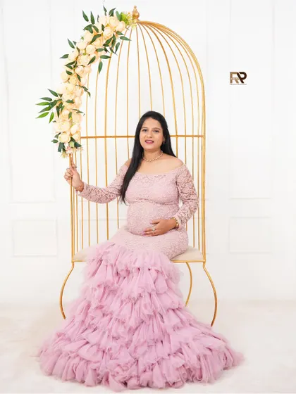 A solo portrait in our golden birdcage. The mom-to-be looks serene and regal in her pink lace and tulle gown, framed by the elegant prop and floral accents.