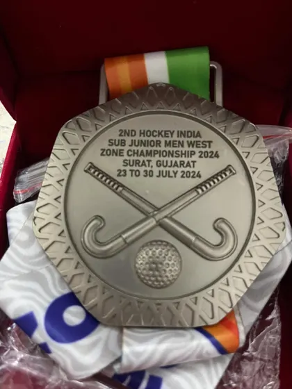 A close-up of the silver medal from the 2nd Hockey India Sub Junior Men West Zone Championship.