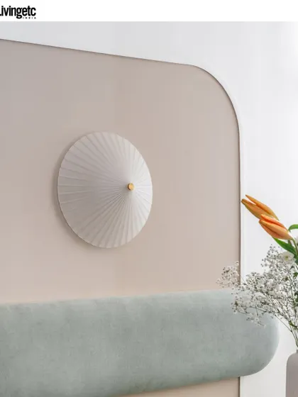 A close-up from the Livingetc feature, highlighting the details of a pleated wall sconce against a soft, curved headboard. This shows my focus on texture, form, and creating a cozy, tactile experience.