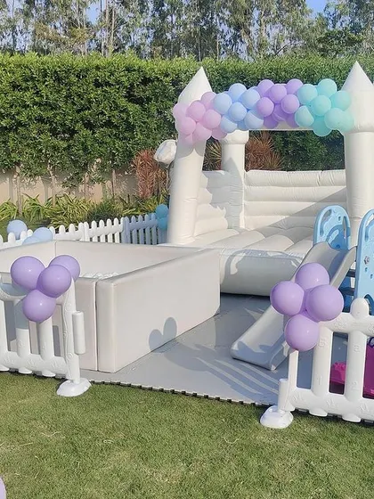 For outdoor parties, a theme-based bouncing castle is a fantastic add-on to keep the kids entertained. This white castle with pastel balloon decor is perfect for a fairy or princess theme.
