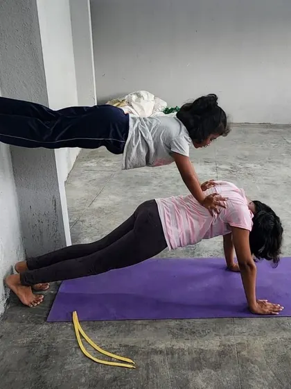 A perfect side view of the wall-assisted double plank, highlighting the straight lines and core engagement.