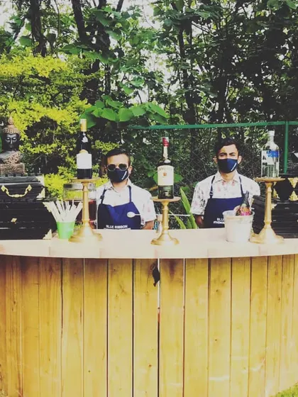 This rustic, circular wooden bar is perfect for a relaxed brunch or an outdoor sundowner. It creates a warm and inviting focal point, shown here fully stocked for a sangria bar and cocktail service.