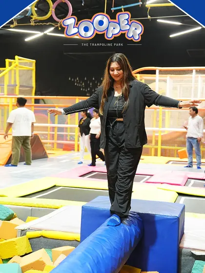 This summer, bounce beats binge-watching. An adult finds her balance on the beam over the foam pit, a fun challenge for any corporate group.