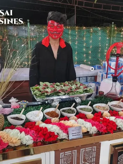 This is my Flavored Paan Station, decorated with flower garlands and staffed by a server in a devil mask. It's a perfect blend of traditional aesthetics and modern, edgy fun.