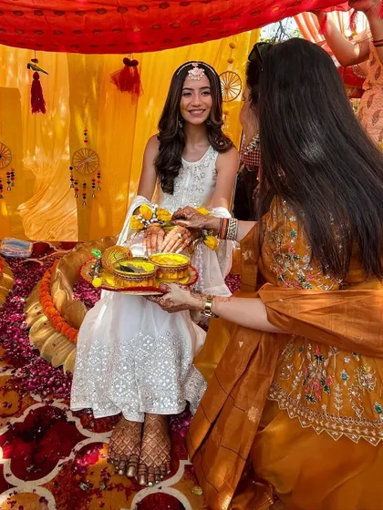 A closer look at Rhea's Haldi ceremony. She chose a subtle yet vibrant white sharara with gottapatti work. I styled it with a delicate matha patti and fresh flower hath phools for a look that was like a dream.
