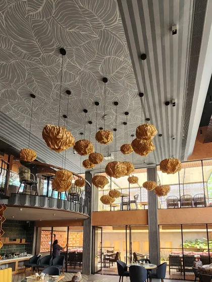 We didn't just stop at the walls for The Koha. We extended the tropical theme to the ceiling with this delicate white leaf line art, which complements the modern lighting fixtures and adds another layer of detail to the space.
