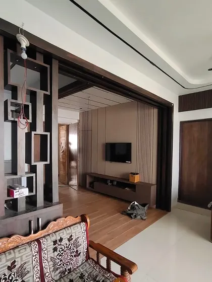 A wider shot of the living room layout, showcasing the open-concept design where the foyer, seating area, and TV zone flow into one another.