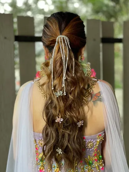 For this carnival themed look, I created a fun and whimsical ponytail with lots of texture, rhinestone chains, and butterfly accessories. It’s all about being playful and creative.