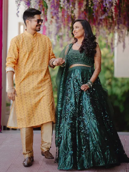 A walking shot of the couple holding hands, sharing a look of love. The floral decor above them adds a touch of wedding magic to this pre-wedding moment.