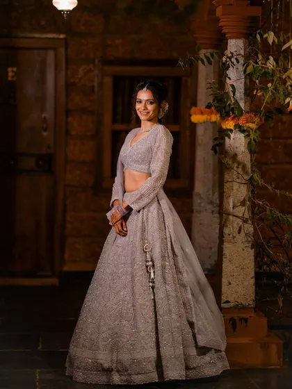 A full-length portrait of the bride, Anusha, smiling brightly at her reception.