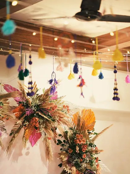 A detailed shot of the floral and tassel decor for a mehendi backdrop. I love combining different textures and colors to create a rich, layered aesthetic.