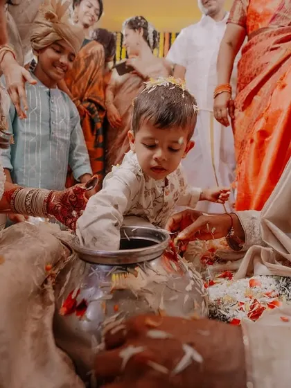 A little one curiously exploring the contents of a pot during a wedding ritual. We are always on the lookout for these adorable, unscripted interactions.