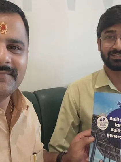Our team member with a customer holding our "Built for Generations" booklet.