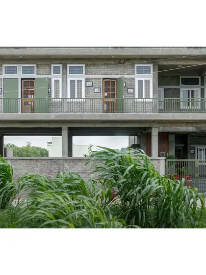 The facade of the ASA office, showing the open ground floor that allows wind and nature to pass through. This passive design strategy, along with deep overhangs, helps keep the entire building cool.