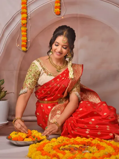 A client looking beautiful while arranging a flower rangoli for Diwali, dressed in a traditional red silk saree from my collection.