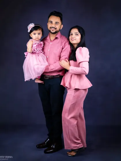 A full-length family portrait showing a stylish family standing together. This shot captures a more formal yet still intimate family moment.