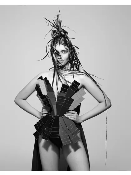 An experimental piece from the "HAIR" series. The model wears a dress made from a fan of color swatches, creating a bold graphic element in this otherwise minimalist black and white world.