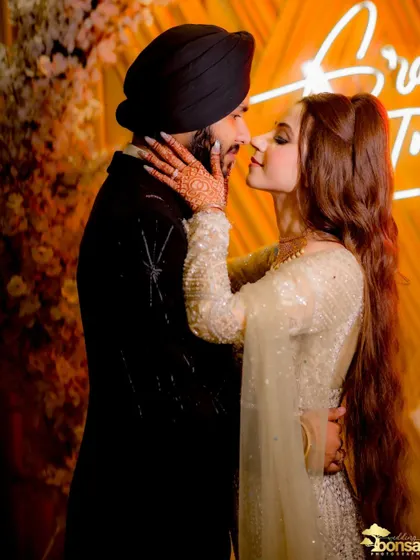 A romantic close-up against a neon sign, capturing the modern and trendy vibe of the engagement party.