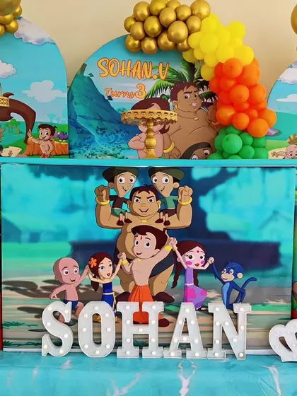 A close-up of a Chhota Bheem-themed setup, showing the character-printed plinths and 'SOHAN' marquee letters.
