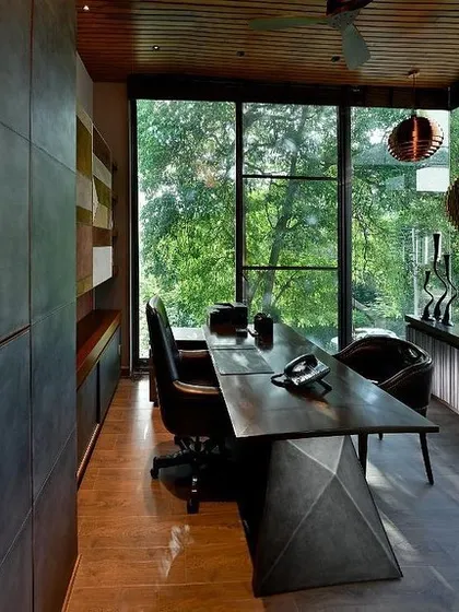 Another view of the T House study, highlighting the custom desk and the seamless connection to the outdoors. The design creates a workspace that feels like a tranquil treehouse, suspended in the green canopy.