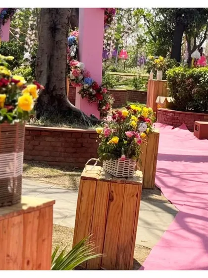 We believe in beautifying every corner. The pathway is lined with rustic wooden crates topped with baskets of fresh, colorful flowers, adding to the garden-like feel of the event.
