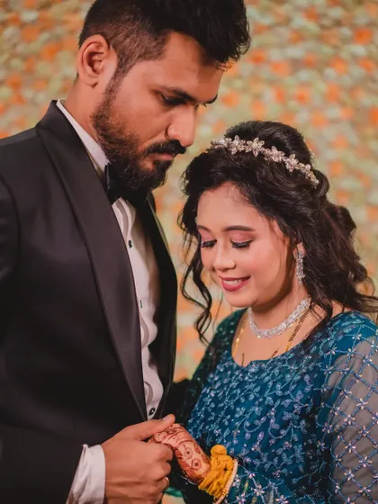 A sweet, candid moment between the couple. You can see the details of her soft, romantic makeup and the delicate hair accessory that completes her reception style.