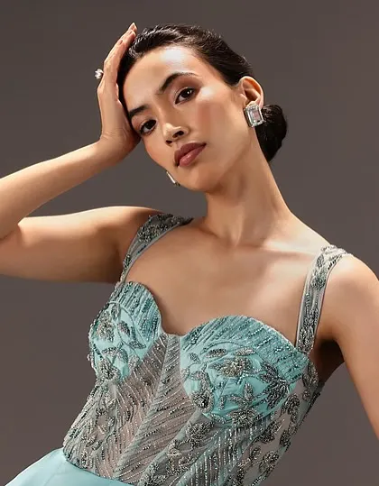 A beautiful portrait highlighting the soft glam makeup. The defined brows and subtle contouring enhance the model's features without overpowering the intricate bustier top.