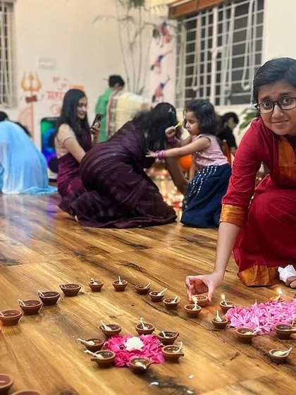 Two students collaborating on the diya arrangement. The path of yoga can be solitary, but the journey is made richer when shared with a supportive community.