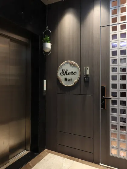 A view of the entrance area showing its position next to the building's elevator. The consistent dark wood paneling creates a private and sophisticated entryway for the apartment.