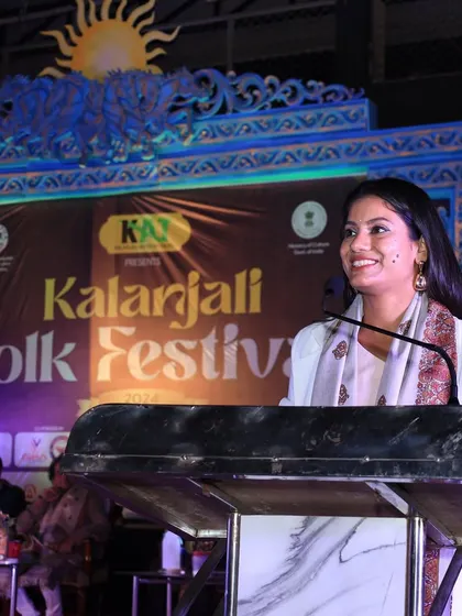 Smiling while speaking at the Kalanajali Folk Festival, feeling connected to the audience.