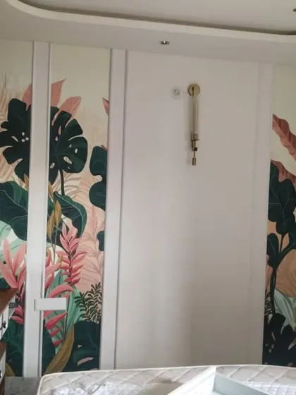 I can also apply wallpaper to furniture, like these wardrobe doors. This project features a vibrant tropical leaf design set within panels, turning standard storage into a stunning design element.
