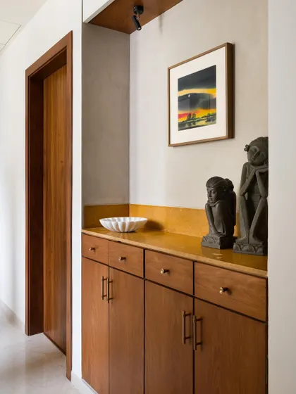 This entry alcove features a custom teak cabinet I designed. It provides a warm welcome and a place to pause, showcasing the client's art and setting a tone of craftsmanship for the home.