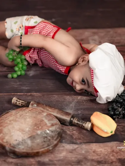 A little chef taking a break from cooking to play with some grapes. We love capturing their playful and mischievous side.