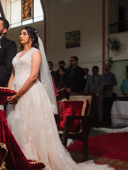 A wide shot of the couple at the altar, capturing the solemnity and beauty of the church ceremony.