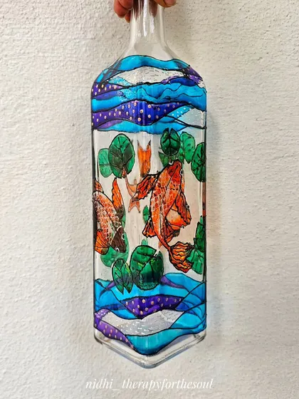 Using glass paints, I created this underwater scene with orange koi fish swimming among lily pads. The transparent quality of the paint makes it feel like you're peering into a little pond.