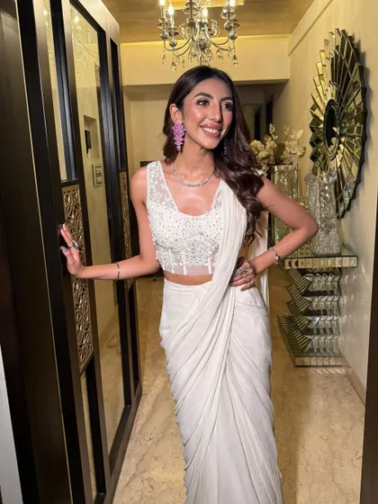 A full-length shot showing the elegant drape of the saree. The overall look is one of modern sophistication.